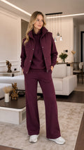 Front view of model wearing burgundy 3-piece tracksuit set with padded vest, hoodie, and wide-leg pants