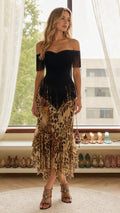 Front view of model wearing off-the-shoulder black and brown leopard fringe midi dress