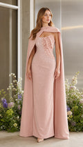 Full front view of blush pink formal evening gown with matching floor-length cape and petal-embellished bodice