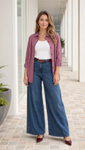 Woman wearing burgundy striped button down shirt with wide-leg jeans, front view
