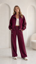 Women's burgundy 2-piece tracksuit set with zip jacket and wide leg pants front view