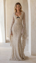 Front view of champagne sequin mermaid gown with dramatic flared bell sleeves and sweetheart neckline